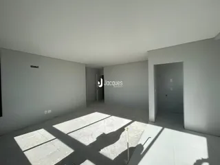Imagem de um espaço interno com paredes brancas e piso de concreto.