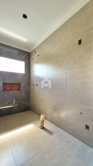 Hall de entrada com piso de cerâmica e paredes claras.