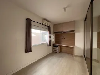 Ambiente interno com piso de madeira clara e janela bem iluminada.