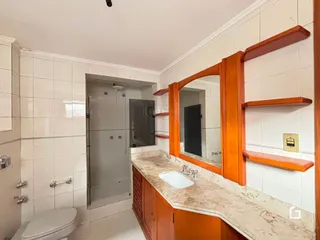 Foto de um banheiro com revestimento cerâmico e bancada de granito.