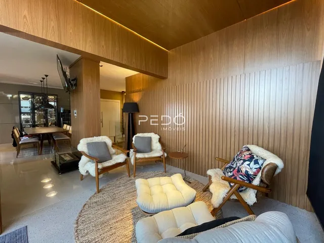 Sala de estar com decoração moderna e painéis de madeira clara.