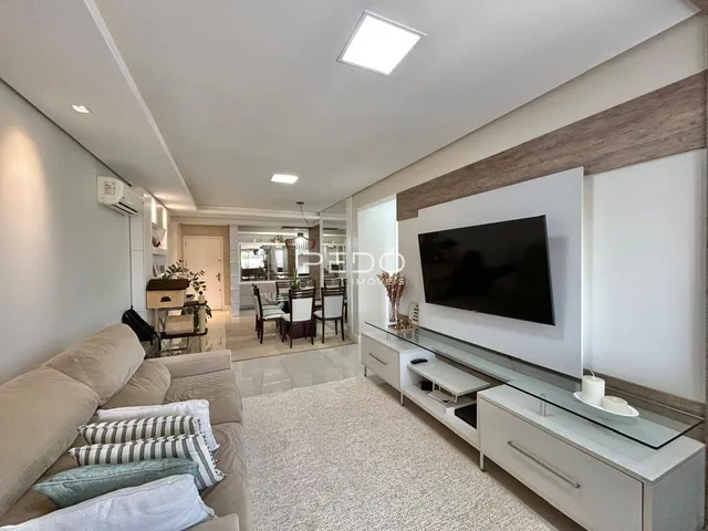 Sala de estar moderna com sofá e televisão em um imóvel no Brasil.
