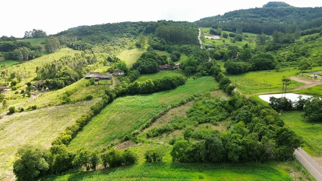 Vista panorâmica de colinas verdes e campos agrícolas em uma paisagem rural.