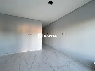Foto de um corredor interno com piso de mármore claro e paredes brancas.