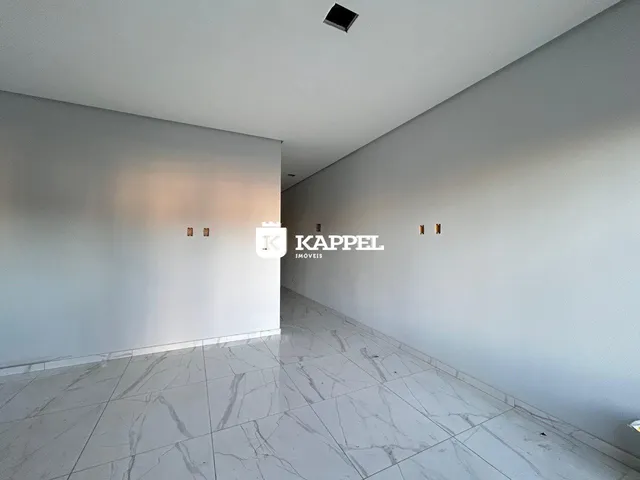 Foto de um corredor interno com piso de mármore claro e paredes brancas.