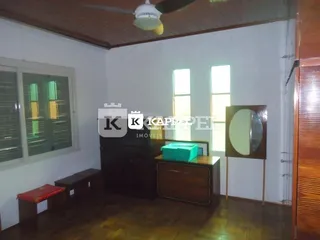 Sala de estar com piso de madeira e móveis escuros.