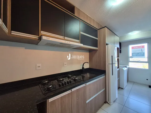 Foto de uma cozinha moderna com armários de madeira e bancadas escuras.