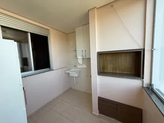 Vista de um corredor interno com piso de cerâmica e uma janela em um imóvel no Brasil.