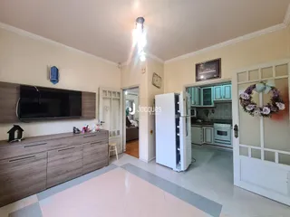 Sala de estar e cozinha de uma residência com piso de cerâmica.