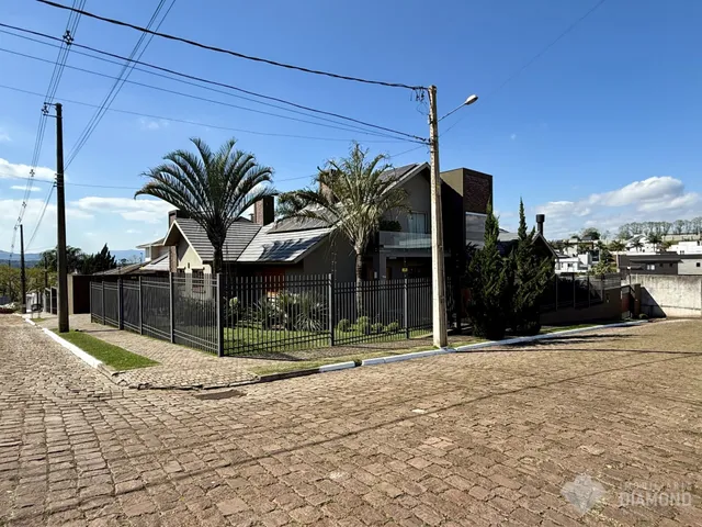 Fachada de uma residência com cerca e vegetação em Lajeado, Brasil.