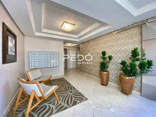 Sala de estar com piso claro e tapete decorativo.