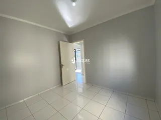 Corredor interno com piso de cerâmica e porta branca.