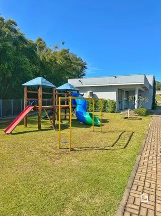 Área externa com gramado e playground em frente à residência.
