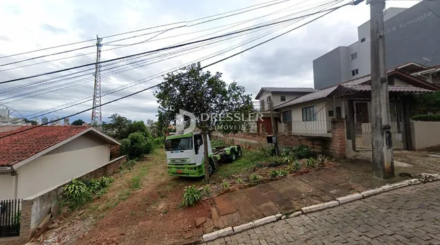 Vista externa de uma propriedade com terreno e estruturas adjacentes.
