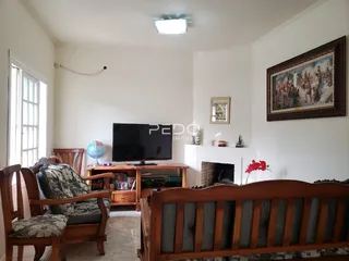 Sala de estar com móveis de madeira e lareira em uma residência.