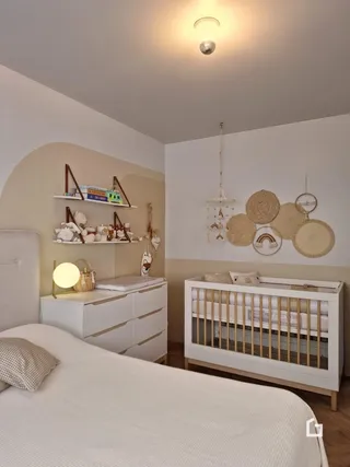 Quarto com cama e móveis brancos.