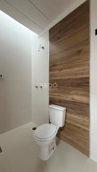 Foto de um corredor com parede de madeira e vaso sanitário.
