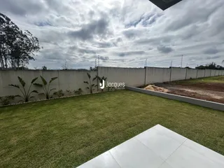 Vista de um jardim gramado com muro de vedação.