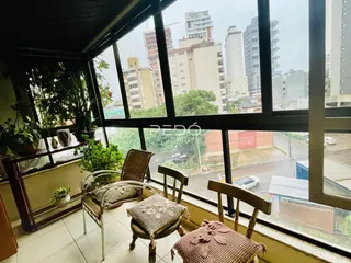 Vista da sala com janelas grandes mostrando a paisagem urbana.