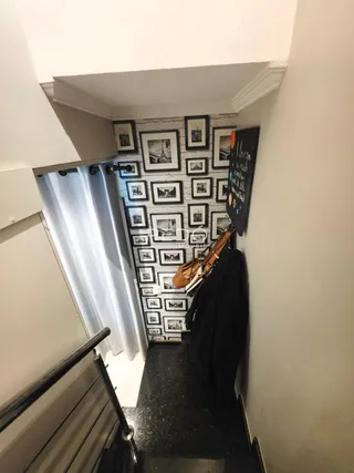 Um corredor com parede decorada com quadros.
