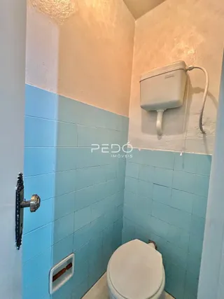 Banheiro com azulejos azuis e brancos na parede.