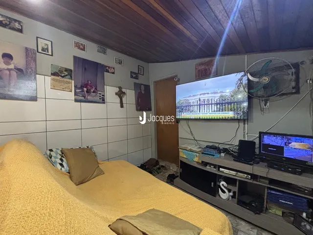 Imagem de uma sala de estar com cama e televisão em um imóvel no Brasil.