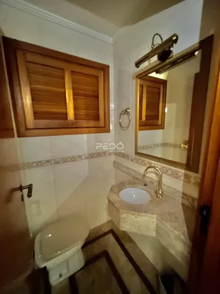 Foto interna de um banheiro com revestimento cerâmico e bancada de mármore.
