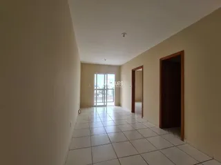 Corredor interno com piso de cerâmica e paredes claras.
