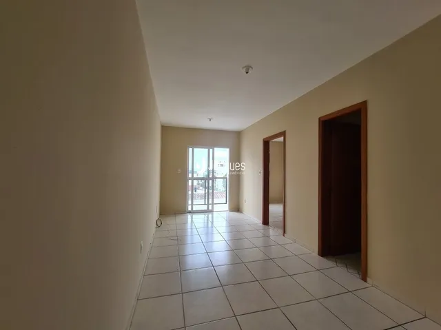 Corredor interno com piso de cerâmica e paredes claras.