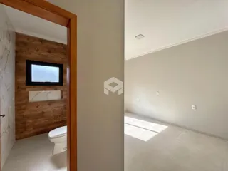 Vista de um corredor e um cômodo interno de uma residência.