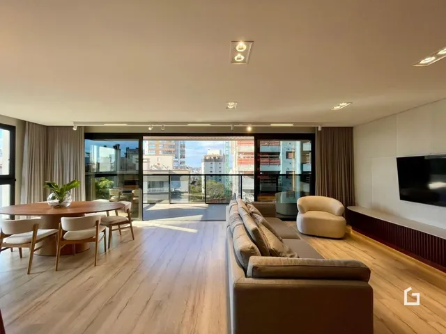 Sala de estar ampla com piso de madeira e acesso à varanda.