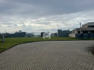 Vista externa de uma propriedade com jardim e área pavimentada.