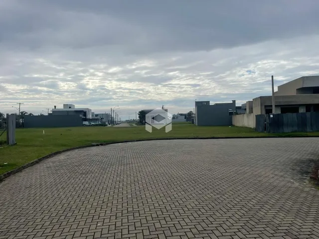 Vista externa de uma propriedade com jardim e área pavimentada.