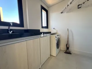 Vista da cozinha com armários brancos e janela.