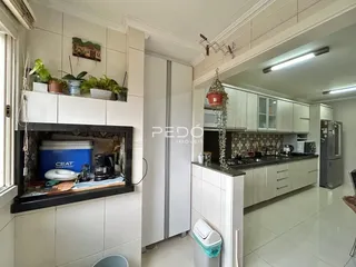 Imagem de uma cozinha moderna com armários brancos e piso claro.