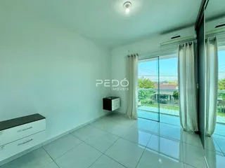 Ambiente interno de uma sala com piso de cerâmica e porta de vidro.