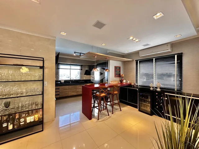 Ambiente moderno de sala de estar, jantar e cozinha em um imóvel.