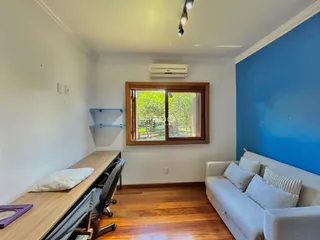 Sala de estar com piso de madeira e parede azul.