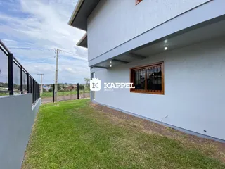 Fachada branca de uma casa moderna com jardim gramado.