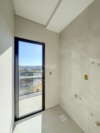 Hall de entrada com porta de vidro e vista da cidade.