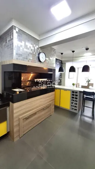 Cozinha moderna com armários de madeira e revestimento de azulejos.