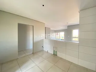 Vista interna de um ambiente com piso de cerâmica e paredes brancas.
