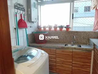 Foto da cozinha mostrando bancada de granito e armários de madeira.