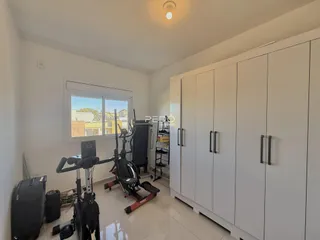 Quarto interno com armários embutidos e equipamentos de ginástica.