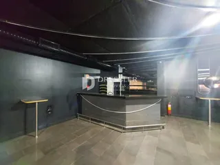 Imagem de um espaço interno com paredes escuras e um balcão de formato curvo.