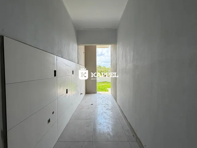 Corredor interno branco com painéis na parede.