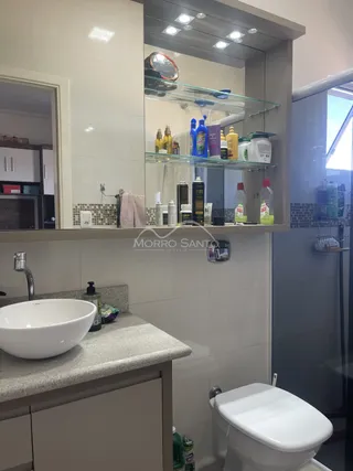 Foto de um banheiro com pia branca e vaso sanitário moderno.