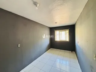 Hall de entrada com piso de cerâmica branca e paredes cinzas.