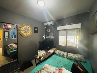 Quarto com paredes cinzas e janela em ambiente residencial.