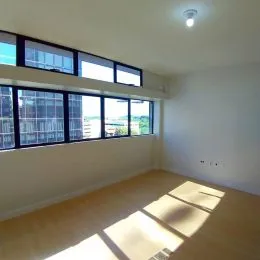 Ambiente interno com grandes janelas que iluminam o espaço.